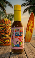 Hot sauce bottle with colorful label against a tropical background with a tiki mask and surfboard.